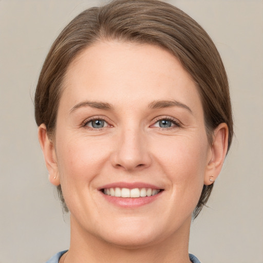 Joyful white young-adult female with short  brown hair and grey eyes