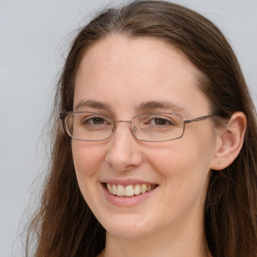 Joyful white adult female with long  brown hair and grey eyes