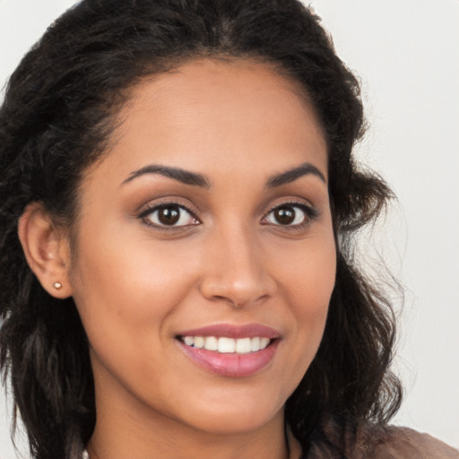 Joyful latino young-adult female with long  brown hair and brown eyes