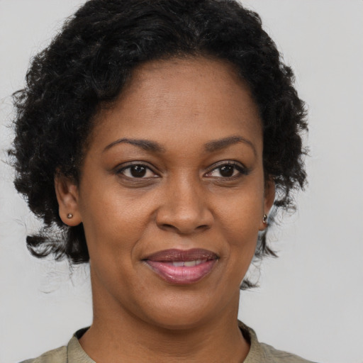 Joyful black adult female with short  brown hair and brown eyes