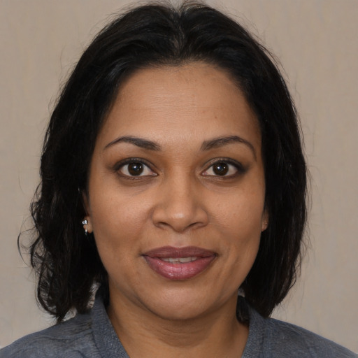 Joyful black adult female with medium  brown hair and brown eyes