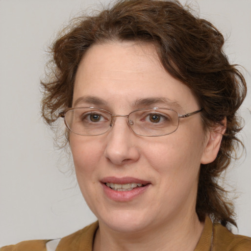 Joyful white adult female with medium  brown hair and blue eyes