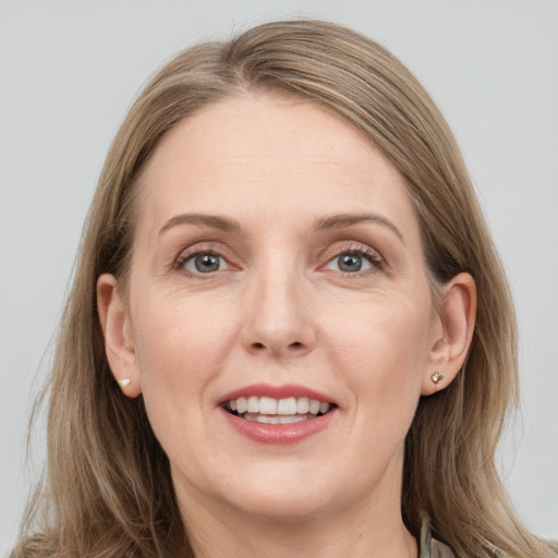 Joyful white adult female with long  brown hair and grey eyes