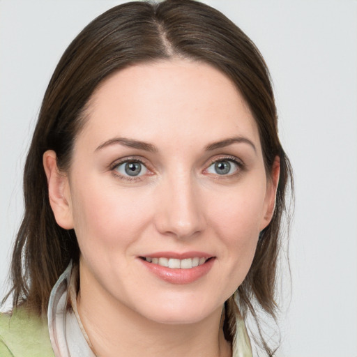 Joyful white young-adult female with medium  brown hair and blue eyes