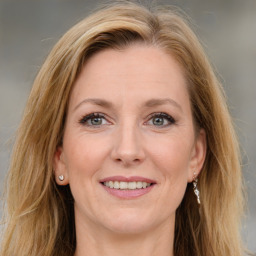 Joyful white adult female with long  brown hair and grey eyes