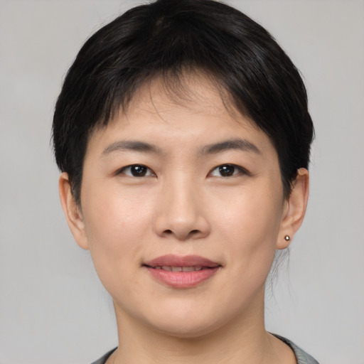 Joyful asian young-adult female with short  brown hair and brown eyes