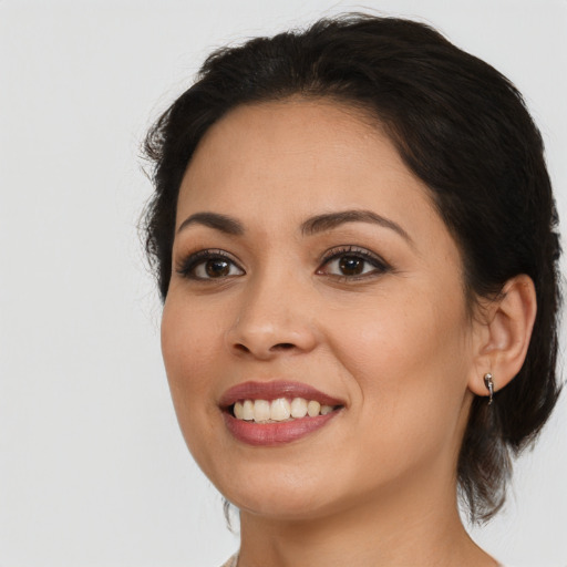 Joyful latino young-adult female with medium  brown hair and brown eyes