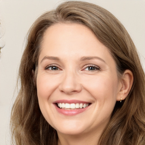 Joyful white adult female with long  brown hair and brown eyes