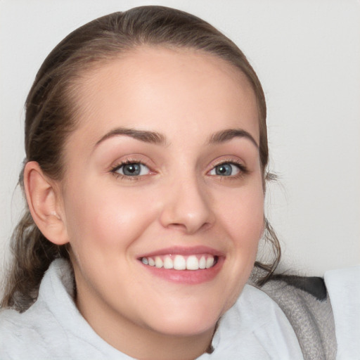 Joyful white young-adult female with medium  brown hair and blue eyes