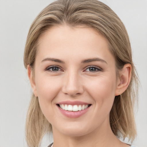 Joyful white young-adult female with medium  brown hair and grey eyes