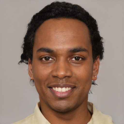 Joyful black young-adult male with short  black hair and brown eyes