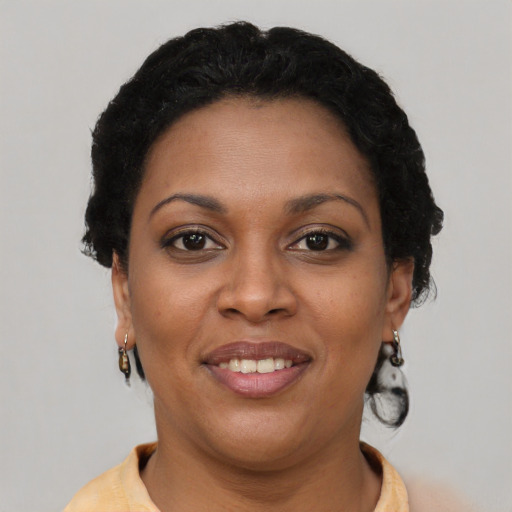 Joyful black young-adult female with short  brown hair and brown eyes