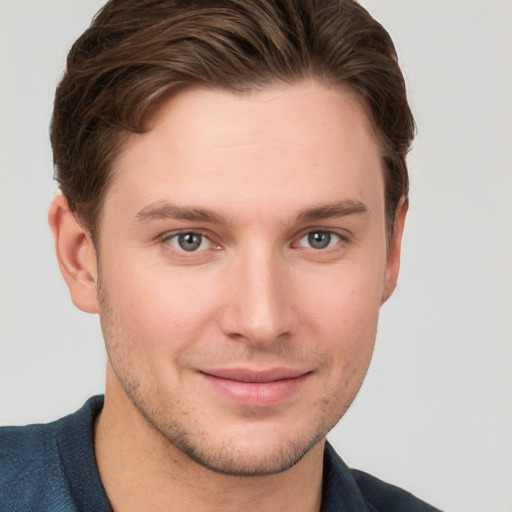 Joyful white young-adult male with short  brown hair and grey eyes