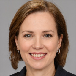 Joyful white adult female with medium  brown hair and grey eyes