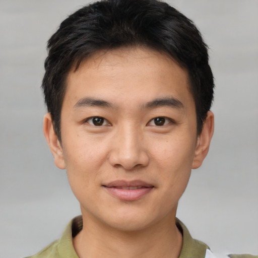 Joyful asian young-adult male with short  brown hair and brown eyes
