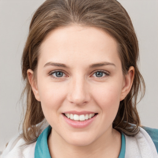 Joyful white young-adult female with medium  brown hair and grey eyes