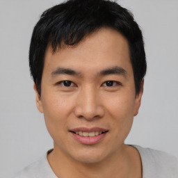 Joyful asian young-adult male with short  black hair and brown eyes