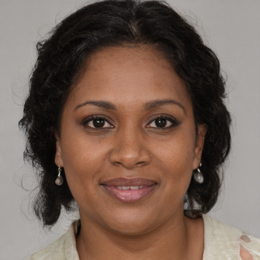 Joyful black young-adult female with medium  brown hair and brown eyes