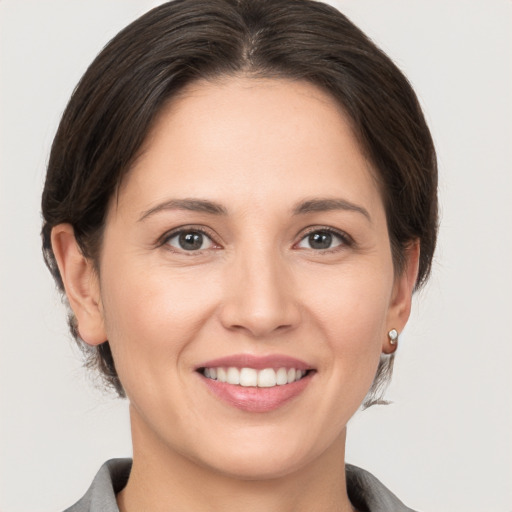 Joyful white young-adult female with medium  brown hair and brown eyes