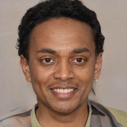 Joyful black young-adult male with short  black hair and brown eyes