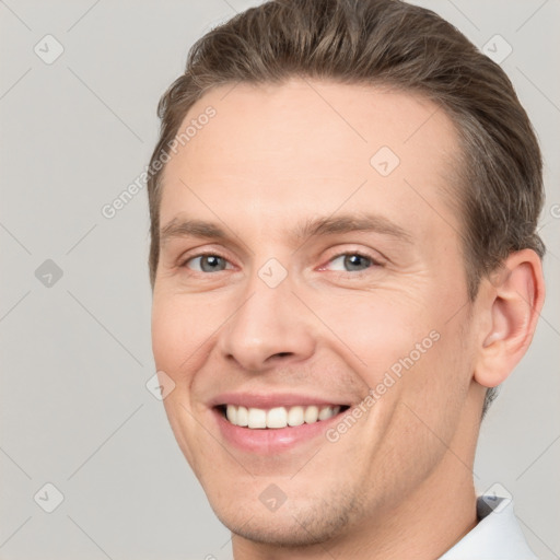 Joyful white young-adult male with short  brown hair and grey eyes