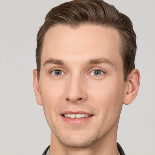 Joyful white young-adult male with short  brown hair and grey eyes