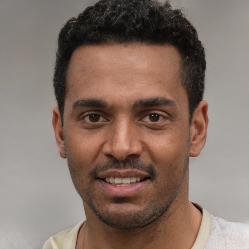 Joyful black young-adult male with short  black hair and brown eyes