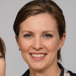 Joyful white adult female with medium  brown hair and grey eyes