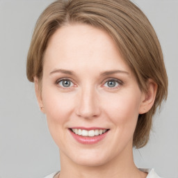 Joyful white young-adult female with medium  brown hair and green eyes