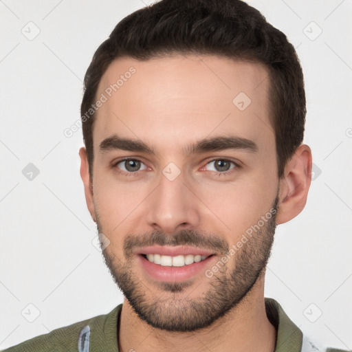 Joyful white young-adult male with short  brown hair and brown eyes