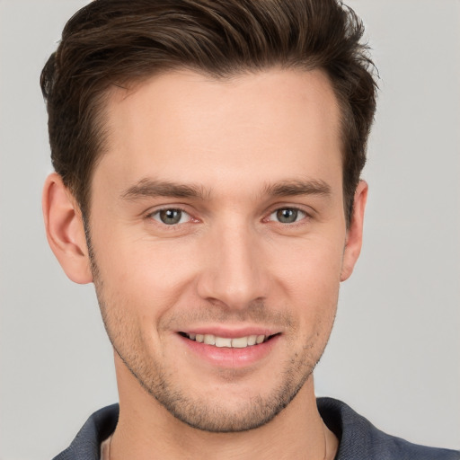 Joyful white young-adult male with short  brown hair and grey eyes