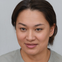 Joyful asian young-adult female with medium  brown hair and brown eyes