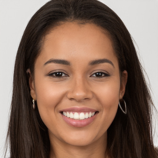 Joyful latino young-adult female with long  brown hair and brown eyes