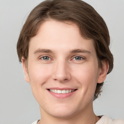 Joyful white young-adult female with short  brown hair and grey eyes