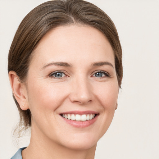 Joyful white young-adult female with medium  brown hair and grey eyes