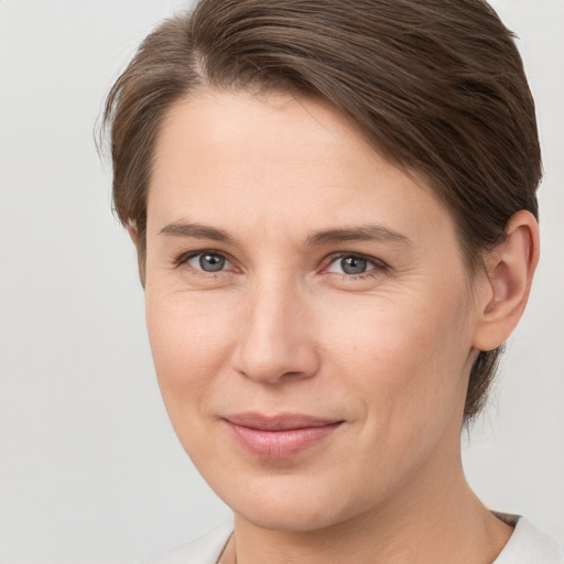 Joyful white young-adult female with short  brown hair and grey eyes