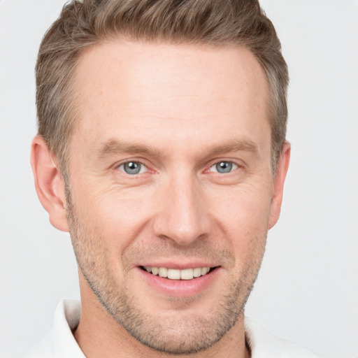 Joyful white adult male with short  brown hair and grey eyes