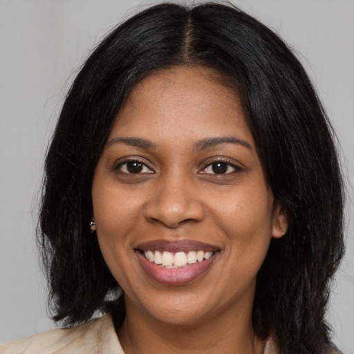 Joyful black young-adult female with long  black hair and brown eyes