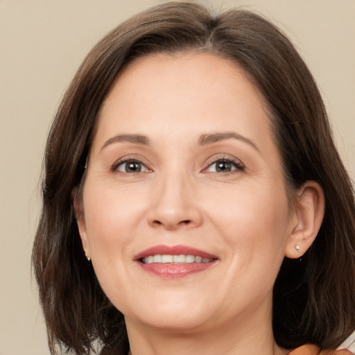 Joyful white adult female with medium  brown hair and brown eyes