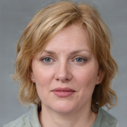 Joyful white young-adult female with medium  brown hair and blue eyes