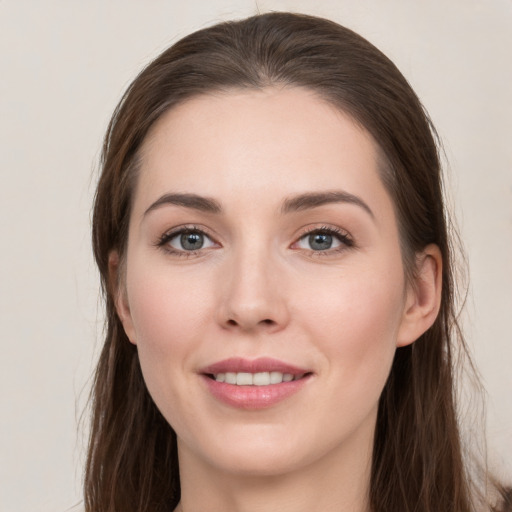 Joyful white young-adult female with long  brown hair and grey eyes