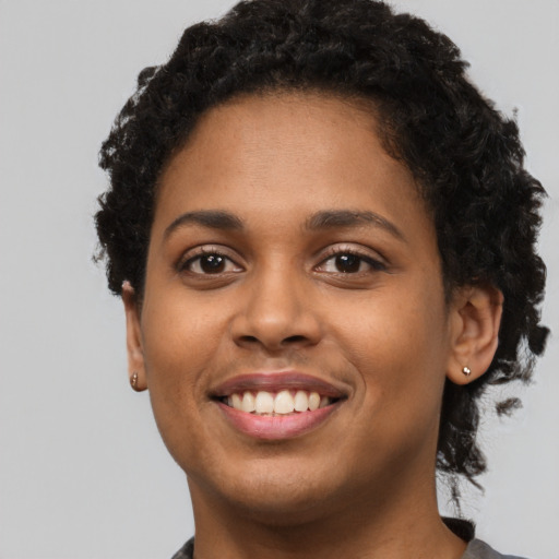 Joyful latino young-adult female with short  black hair and brown eyes
