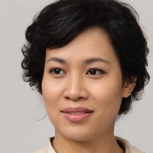 Joyful asian young-adult female with medium  brown hair and brown eyes