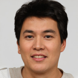 Joyful asian young-adult male with short  brown hair and brown eyes