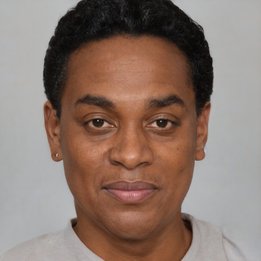 Joyful black adult male with short  black hair and brown eyes