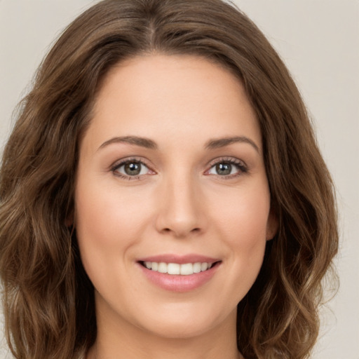 Joyful white young-adult female with long  brown hair and green eyes