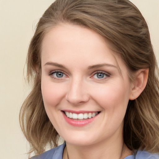 Joyful white young-adult female with long  brown hair and blue eyes