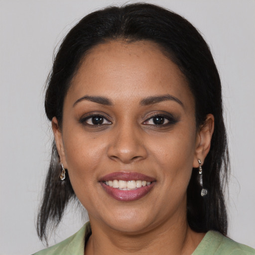 Joyful black young-adult female with medium  brown hair and brown eyes