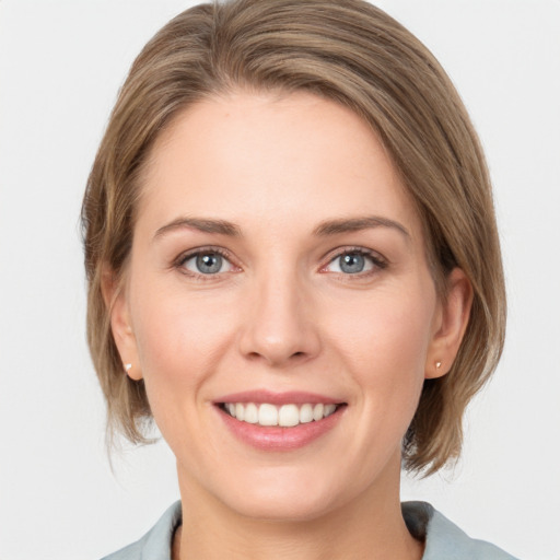 Joyful white young-adult female with medium  brown hair and grey eyes