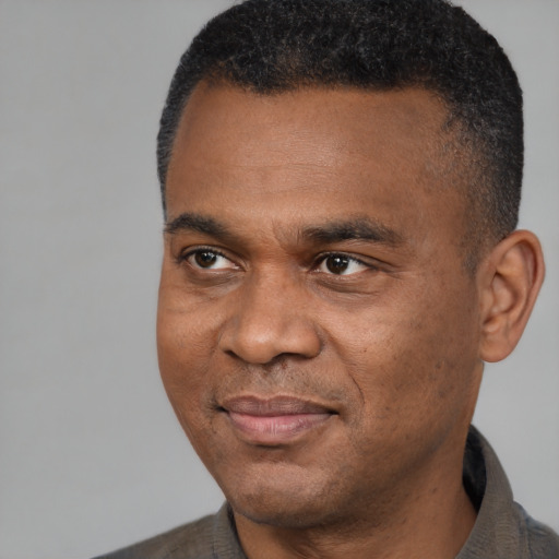 Joyful black young-adult male with short  black hair and brown eyes